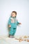 Baby fashion. Unisex clothes for babies. Cute baby in cotton set suit on light background.