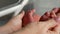 Baby feet in mother hands. Tiny Newborn Baby`s feet on female Heart Shaped hands closeup. Mom and her Child at maternity