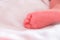 Baby feet sleeping in white bed