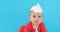 Baby in a foil hat sits on a blue background