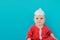 Baby in a foil hat sits on a blue background