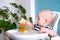 Baby game. Little clever caucasian child playing colorful wood toys making house or tower of cubes on highchair. games