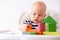 Baby game. Little clever caucasian child playing colorful wood toys sitting on highchair. games for early development