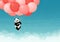 Baby giant panda flying red and pink balloons in the sky with clouds. Black and white chinese bear cub. Rare, vulnerable species.