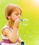 Baby girl blowing soap bubbles