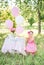 Baby girl celebrates her first birthday with cake and balloons in nature