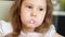 Baby girl with dirty face drinking milk drink - yogurt, smoothies. Breakfast. Portrait close up