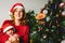 Baby girl dressed as Santa Claus lovingly embraced by her protective mother, family concept at Christmas