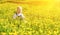 Baby girl on a green meadow with yellow flowers