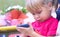 Baby girl holding a mobile phone. Little Caucasian girl playing with smartphone in summer park. Child learning how to