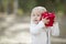 Baby Girl Holding Red Christmas Gift Outdoors