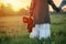 Baby girl holds a teddy bear in his hand at dawn in the grass. The concept of loneliness