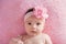 Baby Girl with a Large, Pink, Flower Headband and Pearls