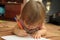 Baby girl learning to write and paint in home environment lying on carpet. Early brain education development concept