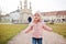 Baby girl with lollipop, wear pink jacket walking at Valtice town, Czech Republic