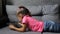 Baby girl lying on sofa with tablet. Little girl lying playing on tablet