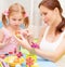 Baby girl with mother paint Easter eggs