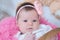 Baby girl newborn portrait in pink blanket lying in basket, cute face, new life