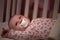 Baby Girl With Pacifier Lying In Cot