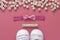 Baby girl pink background with newborn shoes, bow and Welcome words. Baby flat lay