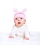 Baby girl in a pink hat with rabbit ears isolated on white