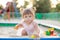 Baby girl playing in sandbox in kindergarten.ittle girl plays with toys in the sand.