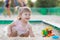 Baby girl playing in sandbox in kindergarten.ittle girl plays with toys in the sand.