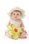 Baby girl in pretty hat plays with toy flower