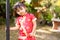 Baby girl in red Chinese outfit playing in garden