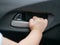 Baby girl`s hand about to pull the door handle from inside of a moving car