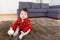 Baby girl sitting on carpet with water bottom and doll