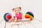 Baby girl sitting near multicolored balls