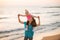 Baby girl sitting on shoulders of mother on beach