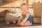 Baby Girl sitting and Smiling near Wooden Barn