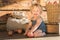 Baby Girl sitting and Smiling near Wooden Barn