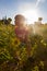 A baby girl standing in a sunflower field in the sunset