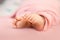 Baby girl tiny toes on pink background in a selective focus, maternity and babyhood concept