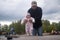 Baby girl walking outdoors with man. Granfather helping his granddaughter to walk