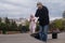 Baby girl walking outdoors with man. Granfather helping his granddaughter to walk