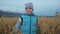 Baby girl walking in wheat field. Kid runs against the backdrop of beautiful mountains with snow capped peaks. Child