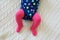 Baby girl wearing pink tights and colorful onesie