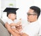 Baby with graduation cap holding certificate