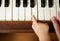 Baby hand playing piano with adult hand