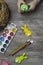 baby hand turn easter egg. In wooden table paints, brushes, bunny, nest