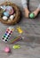 baby hand turn easter egg. In wooden table paints, brushes, bunny, nest