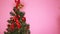 Baby hands of a little girl decorating the Christmas tree with Christmas toys