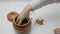 Baby hands play with the grain of buckwheat in a pot on white table