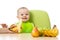Baby having a table full of healthy food. Cheerful toddler with fruits apples, bananas, pear. Isolated on white
