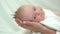 Baby head on mother hands, helpless newborn look, parent protection