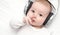 Baby with headphone lies on back